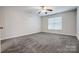 Empty bedroom with a ceiling fan, a large window with blinds, and gray carpet at 201 Chestnut Ave, Tega Cay, SC 29708