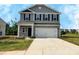 Charming two-story home featuring gray siding, black shutters, and a spacious two-car garage at 213 Lake George Dr, Shelby, NC 28152