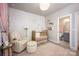 A bright and cheery Bedroom featuring a gold crib, chair with ottoman, and ensuite bathroom at 2306 Elizabeth Mill Pl, Charlotte, NC 28208