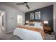 Main bedroom with a dark accent wall, ceiling fan, and a door leading to the main bathroom at 2306 Elizabeth Mill Pl, Charlotte, NC 28208