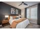 Comfortable main bedroom with a dark accent wall, a ceiling fan, and lots of natural light at 2306 Elizabeth Mill Pl, Charlotte, NC 28208