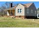 Charming two-story home featuring a cozy front porch, a brick chimney, and a mix of beige and gray siding at 2318 W Main St, Albemarle, NC 28001