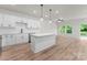 Open floor plan showcasing kitchen with white cabinets, stainless appliances, large island and access to the back deck at 2825 New Pineola Rd # 7A, Charlotte, NC 28208