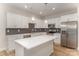 Well-lit kitchen with white cabinetry, stainless steel appliances, an island, and backsplash at 2825 New Pineola Rd # 7A, Charlotte, NC 28208