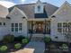 Inviting front porch with elegant wood door, comfortable seating, and stylish brickwork at 329 Wintergreen Ct, Kings Mountain, NC 28086
