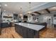 Open-concept kitchen and living room featuring a large island, modern lighting, and a cozy fireplace at 329 Wintergreen Ct, Kings Mountain, NC 28086