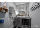 A well-organized laundry room with modern appliances and stylish decor, including shelving and patterned wallpaper at 329 Wintergreen Ct, Kings Mountain, NC 28086