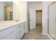 Bright bathroom featuring double vanity, stone floors, a large mirror, and a glass-enclosed shower at 3928 Craig Ave, Charlotte, NC 28211