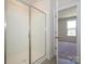 Shower with glass doors and white tile, with view into carpeted bedroom and an open, bright window at 3928 Craig Ave, Charlotte, NC 28211