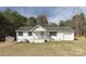 Charming single-story home with white siding, a cozy front porch, attached garage, and a lush backdrop of mature trees at 4175 Barnell Ln, Maiden, NC 28650
