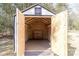 Open shed doors showcasing a finished interior with ample storage space and a sturdy workbench for projects at 4175 Barnell Ln, Maiden, NC 28650