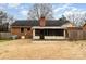 Spacious backyard featuring a brick house, sunroom, and expansive lawn area at 4815 Carriage Drive Cir, Charlotte, NC 28205