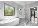 A modern bathroom featuring a soaking tub, glass enclosed shower, and marble floors at 6233 Riviera Run Estates Dr, Hickory, NC 28601