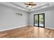Bedroom with a tray ceiling, ceiling fan, wood floors, and access to a balcony at 6233 Riviera Run Estates Dr, Hickory, NC 28601