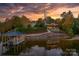 Stunning lakefront home with boat dock and lush landscaping at sunset at 6233 Riviera Run Estates Dr, Hickory, NC 28601