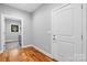 Hallway with hardwood floors leading to laundry room featuring gray tile and sink at 6233 Riviera Run Estates Dr, Hickory, NC 28601