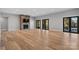 Open-concept living room with stone fireplace, wood floors, and doors to the outdoor porch at 6233 Riviera Run Estates Dr, Hickory, NC 28601