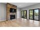 Open living room featuring a stone fireplace and doors to the deck at 6233 Riviera Run Estates Dr, Hickory, NC 28601