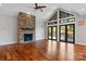 Bright living room with a stone fireplace, hardwood floors, and access to an outdoor deck through glass doors at 6233 Riviera Run Estates Dr, Hickory, NC 28601