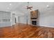 Large open-concept living room with gorgeous hardwood flooring, a stone fireplace, and neutral wall colors at 6233 Riviera Run Estates Dr, Hickory, NC 28601