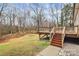 A beautiful home back exterior view showcases the deck, grassy yard and mature trees beyond at 642 Brynwood Dr, Rock Hill, SC 29732