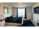 Modern bedroom with a sleek bed frame, white dresser, large window, and stylish black accents at 7711 Bainbridge Rd, Sherrills Ford, NC 28673