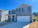 Charming two-story home featuring stone accents, a two-car garage, and manicured lawn on a sunny day at 7711 Bainbridge Rd, Sherrills Ford, NC 28673