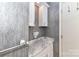 Elegant powder room with marble countertop and stylish gray textured wallpaper at 84 Ridgeport Rd # B, Clover, SC 29710