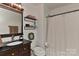Charming bathroom with wood vanity, mirror, toilet, and shower with curtain at 9414 Machado Dr, Indian Trail, NC 28079