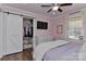 A bedroom with a sliding closet door, pink walls, and a ceiling fan at 9414 Machado Dr, Indian Trail, NC 28079