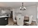 Elegant dining area with a round wooden table surrounded by upholstered chairs, adjacent to the kitchen at 9414 Machado Dr, Indian Trail, NC 28079