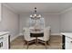 Cozy dining area features a wooden table with upholstered chairs and modern chandelier lighting at 9414 Machado Dr, Indian Trail, NC 28079