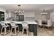 Bright kitchen with white cabinets, a large center island, and an adjacent dining area with stylish lighting at 9414 Machado Dr, Indian Trail, NC 28079
