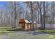 Rustic storage shed with a covered porch surrounded by bare trees at 9414 Machado Dr, Indian Trail, NC 28079