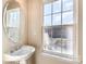 Bright bathroom featuring a pedestal sink, an oval mirror and a window providing natural light at 9534 Blossom Hill Dr, Huntersville, NC 28078