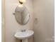 Elegant bathroom with a pedestal sink, oval mirror, and classic fixtures enhancing its timeless appeal at 9534 Blossom Hill Dr, Huntersville, NC 28078