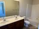Bathroom featuring double sinks, a large mirror, modern fixtures, and a tub with shower at 9534 Blossom Hill Dr, Huntersville, NC 28078