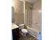 Clean bathroom with a sink, toilet, and a shower-tub combo with white tile surround at 9534 Blossom Hill Dr, Huntersville, NC 28078