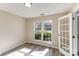 Bright bedroom with hardwood floors, complemented by natural light from double windows and a glass panel door at 9534 Blossom Hill Dr, Huntersville, NC 28078