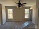 Bedroom filled with natural light, featuring carpeted floors, a ceiling fan, and two large windows at 9534 Blossom Hill Dr, Huntersville, NC 28078