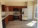 Well-lit kitchen with stainless steel appliances, wood cabinets, and modern laminate flooring at 9534 Blossom Hill Dr, Huntersville, NC 28078