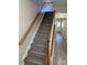 Carpeted staircase with wooden handrail, complemented by hardwood floors in a bright, inviting hallway at 9534 Blossom Hill Dr, Huntersville, NC 28078