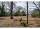 Spacious backyard with mature trees and wooden Adirondack chairs at 1120 Cumberland Ave, Gastonia, NC 28054
