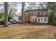 Brick home's backyard featuring mature trees and parking for multiple cars at 1120 Cumberland Ave, Gastonia, NC 28054