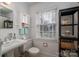 Bright bathroom featuring a pedestal sink and textured walls at 1120 Cumberland Ave, Gastonia, NC 28054