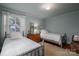 Bright bedroom with two twin beds, hardwood floors, and a window with white curtains at 1120 Cumberland Ave, Gastonia, NC 28054