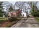 Side view showing a brick house with a white detached garage and a private driveway and yard with patio furniture at 1120 Cumberland Ave, Gastonia, NC 28054