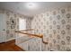 Upstairs hallway featuring floral wallpaper and wooden banister on the staircase at 1120 Cumberland Ave, Gastonia, NC 28054