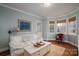 Cozy living room featuring a white sofa, coffee table, and natural light from bay windows at 1120 Cumberland Ave, Gastonia, NC 28054