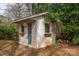 Charming shed featuring a blue door and surrounding foliage at 1120 Cumberland Ave, Gastonia, NC 28054